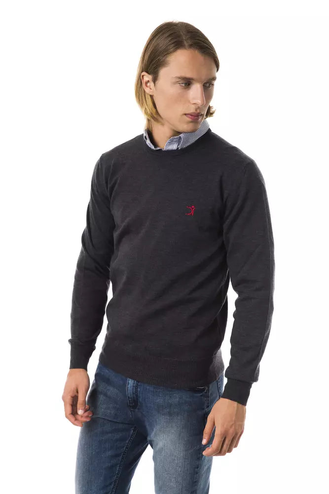 Man wearing dark sweater with logo on chest