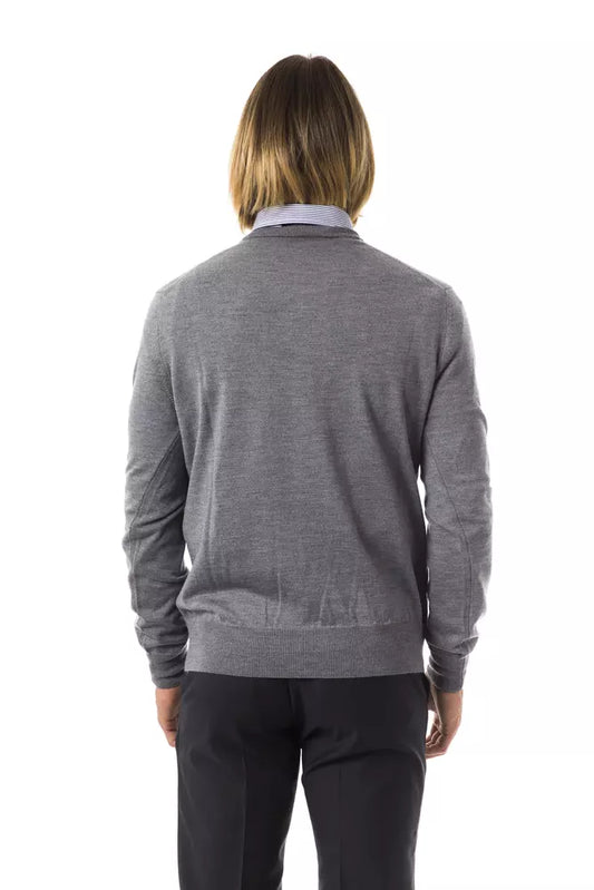 The back view of a person wearing a gray sweater and black pants