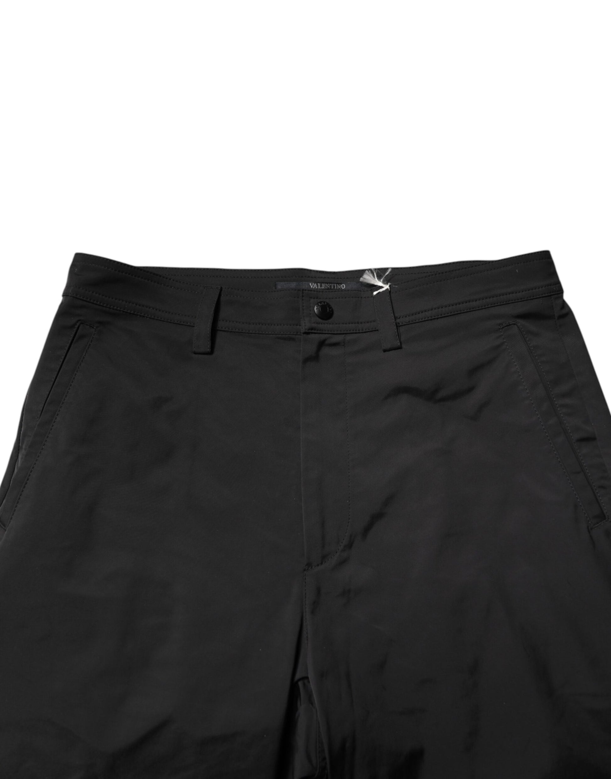 A pair of black men's trousers with a mid-waist design, tapered legs and visible stitching details