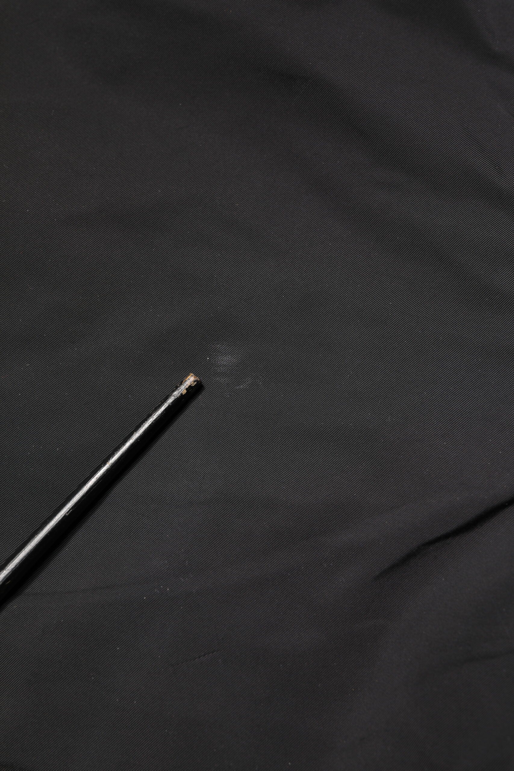 A pair of black men's trousers with a mid-waist design and tapered legs