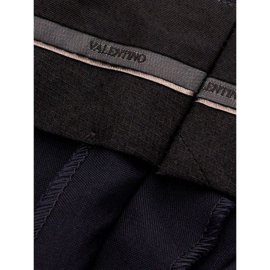 A pair of black wool dress pants with a label on the waistband