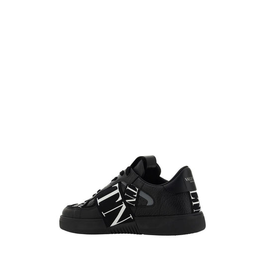 Black sneaker with white laces and patterned design on side