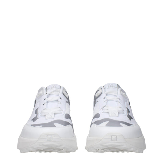 Pair of white athletic sneakers with camouflage pattern on sides, featuring a low-top design and lace closure