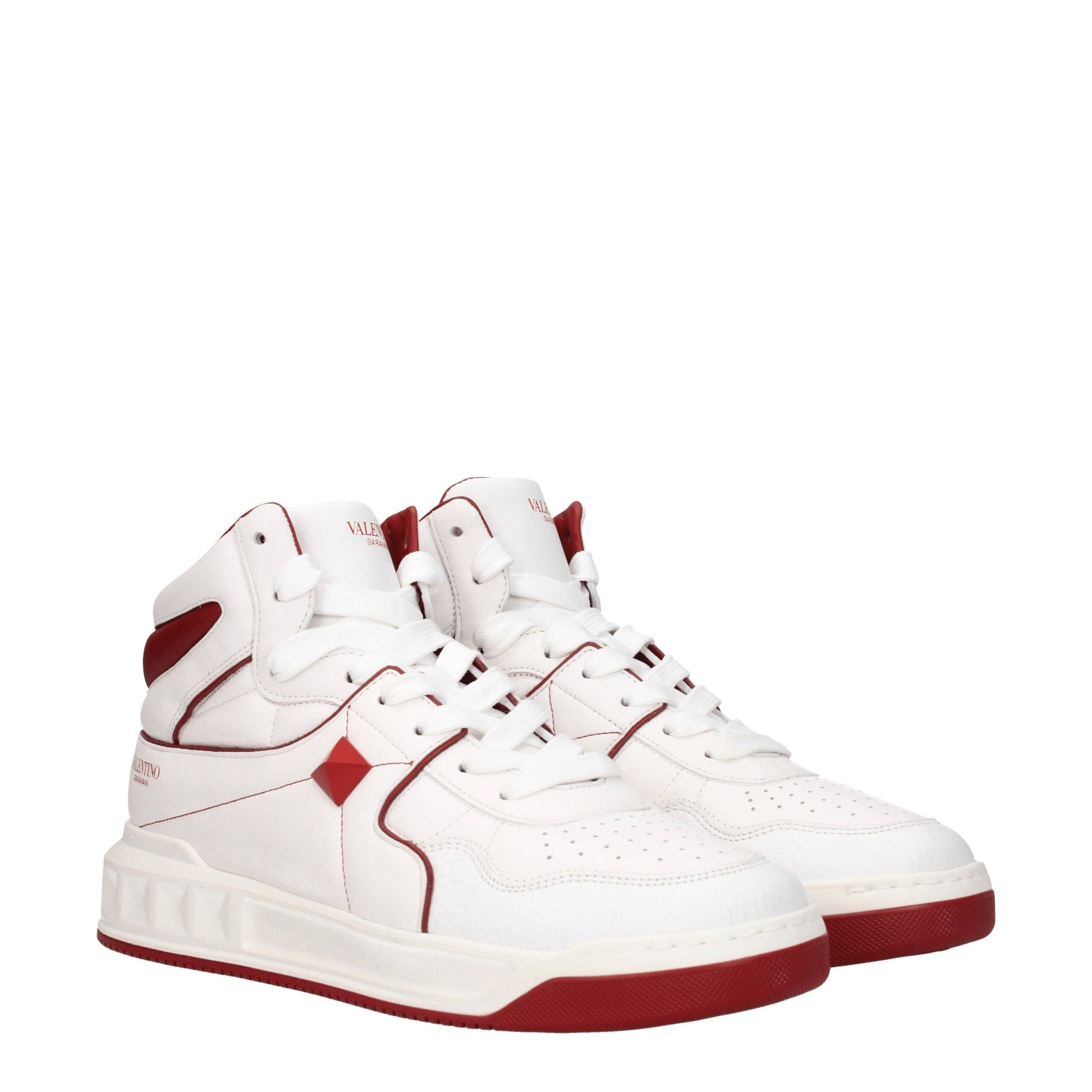 White leather high top sneakers with red accents, laces, and sole