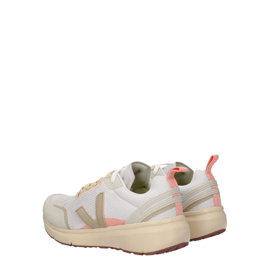 Pair of beige athletic sneakers with pink accents, featuring a lace-up front and chunky soles