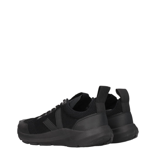 Pair of black athletic sneakers with laces, featuring a knit upper and a chunky sole design