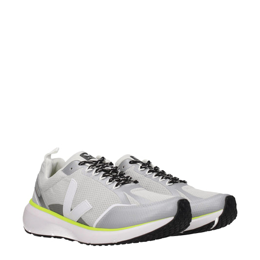 Pair of gray athletic sneakers with yellow accents, featuring a knit upper and lace closure