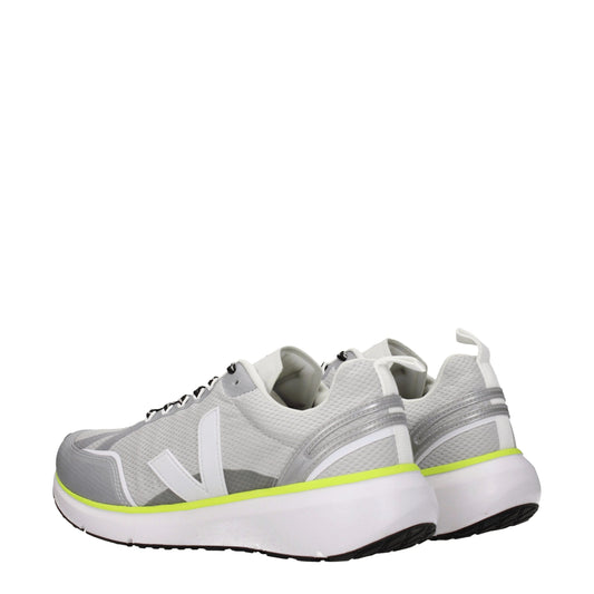 Pair of gray athletic sneakers with yellow accents, featuring a knit upper and a rubber sole