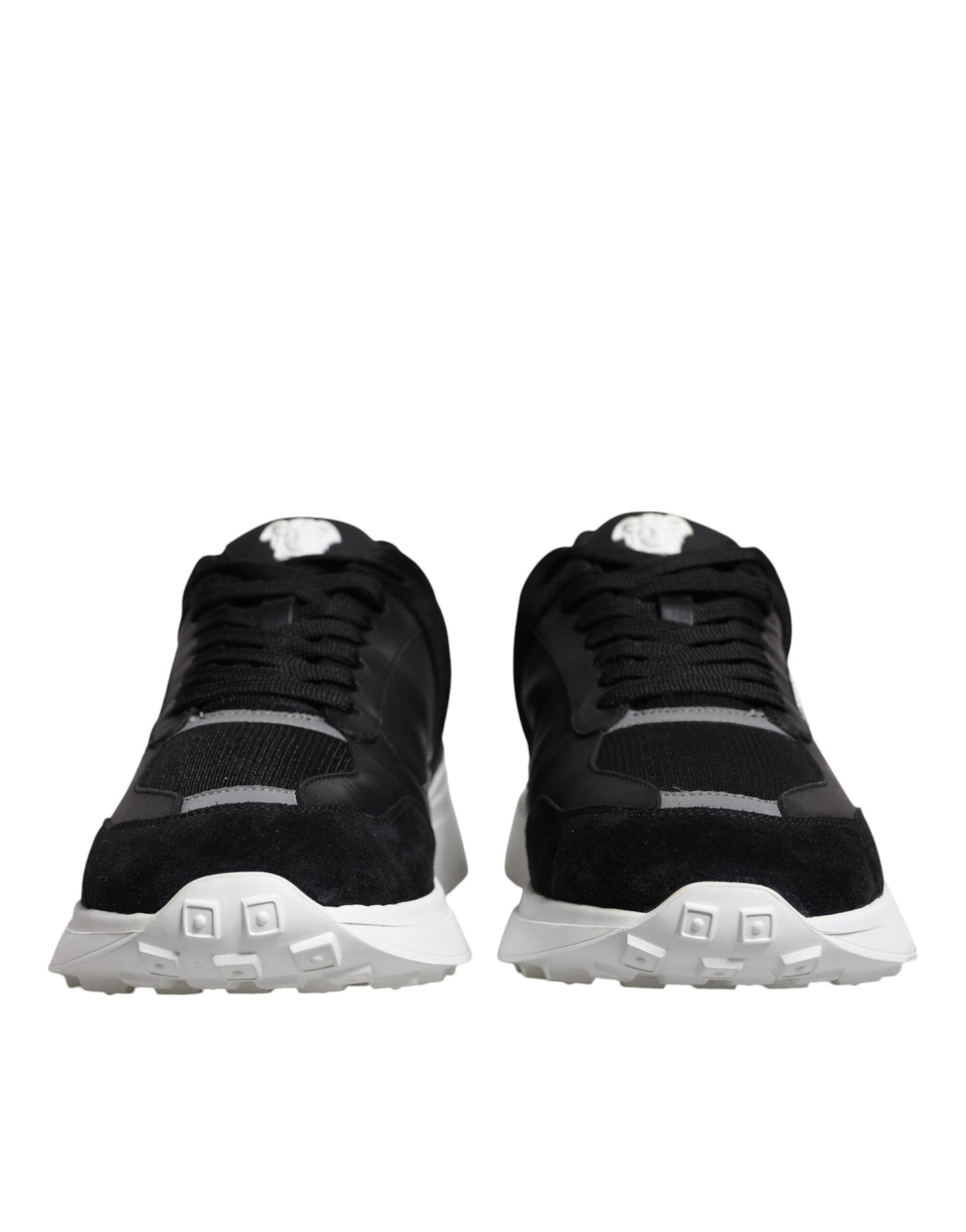 Pair of black canvas sneakers with white soles and laces, featuring a low top design