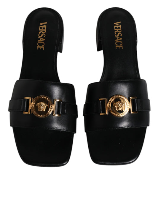 Pair of black sandals with gold buckles