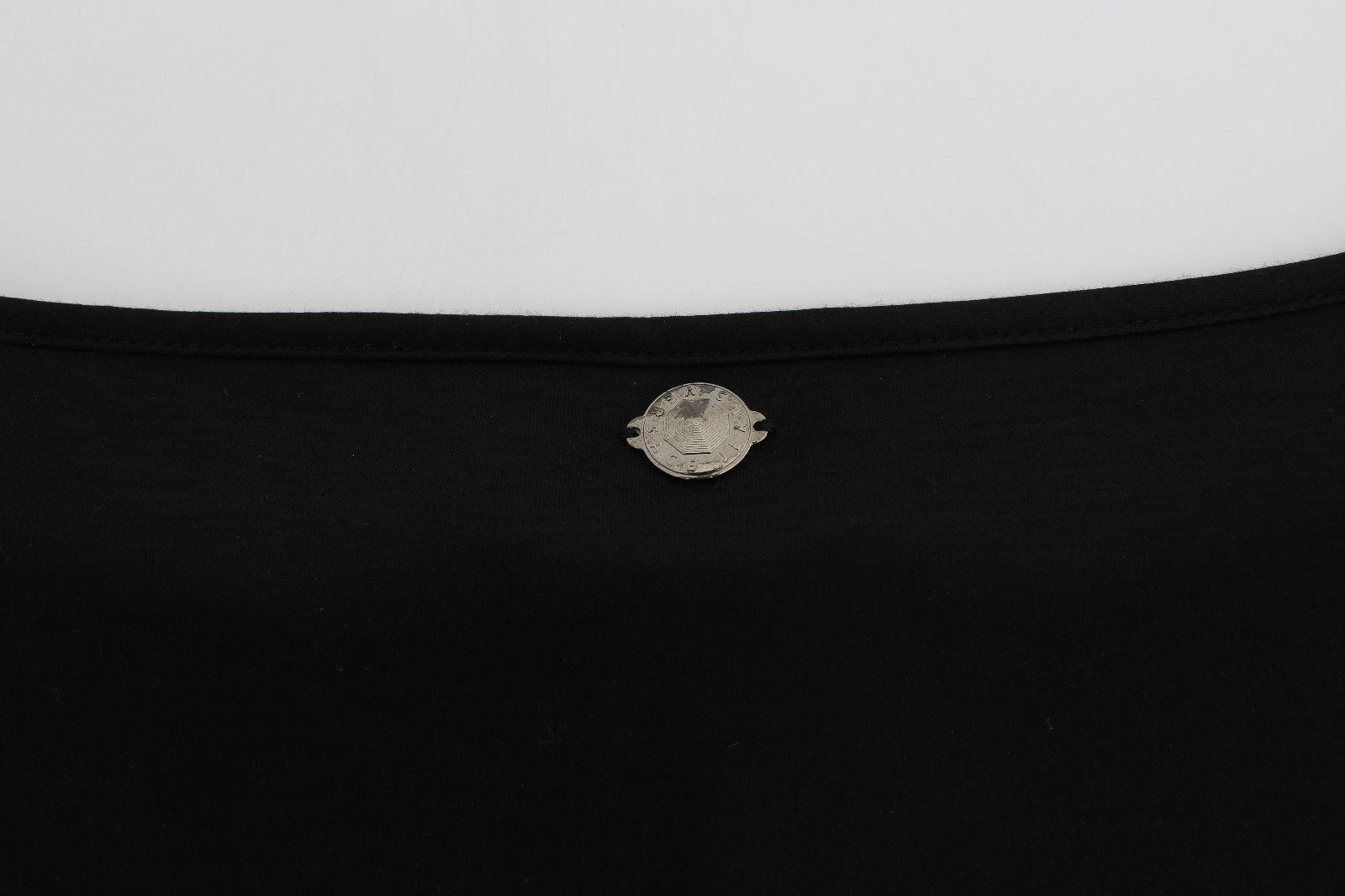 Black shirt with a small silver button on the front