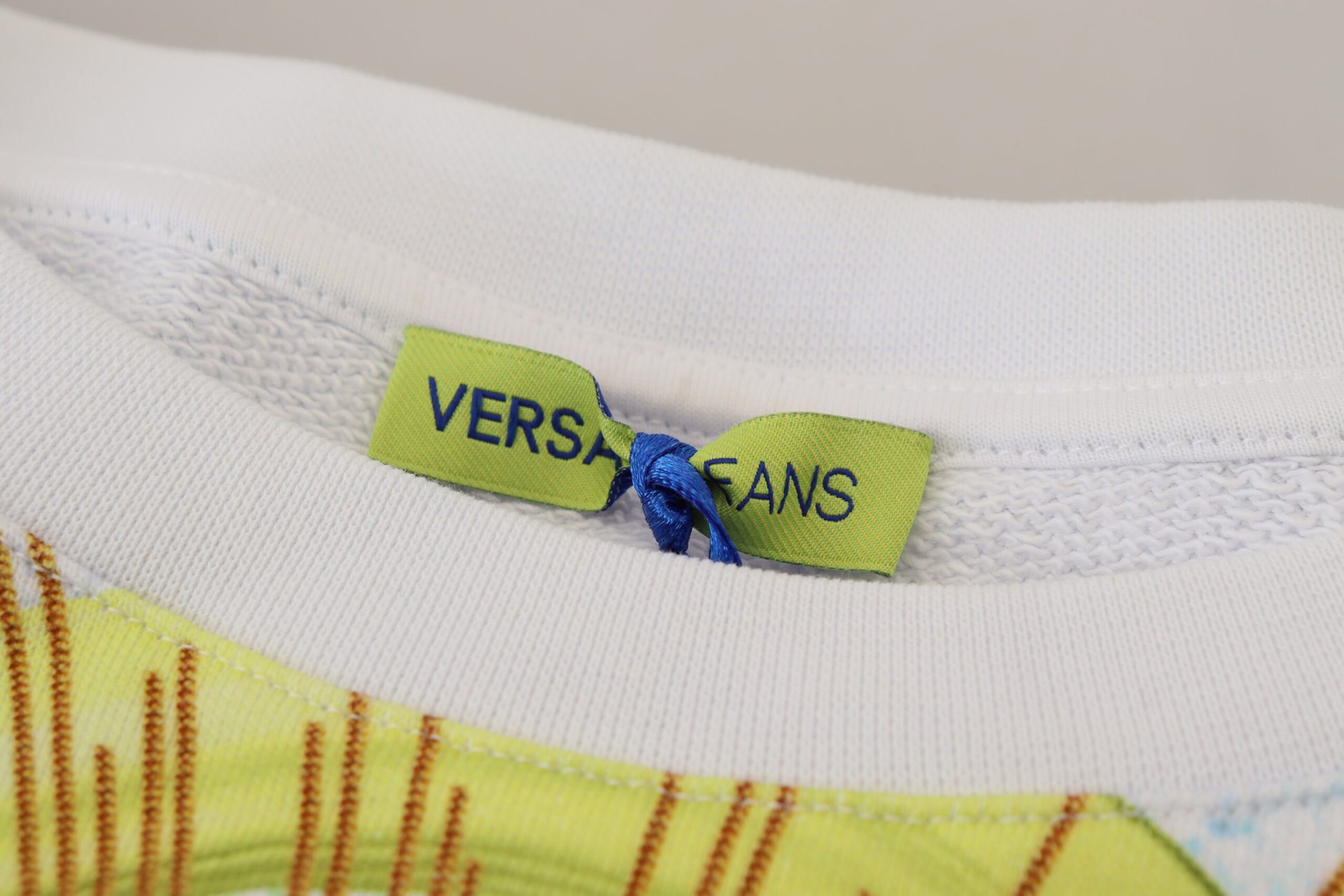 White sock with yellow stripes and blue label reading "VERSATILE