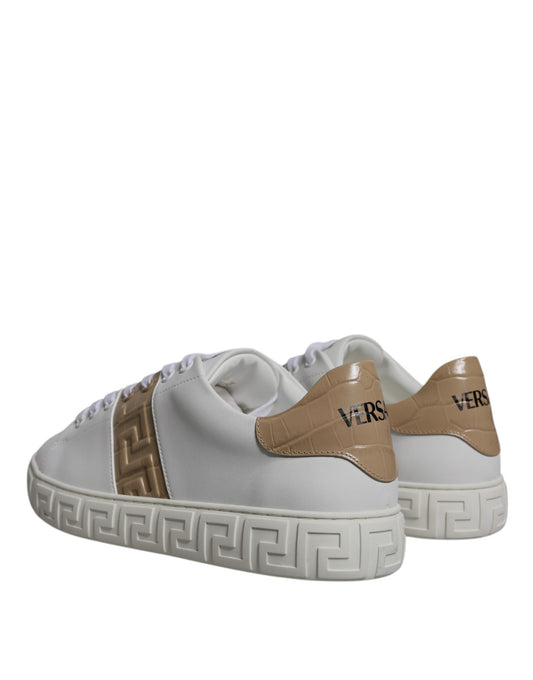 Pair of white sneakers with tan accents and a Greek key design on the side
