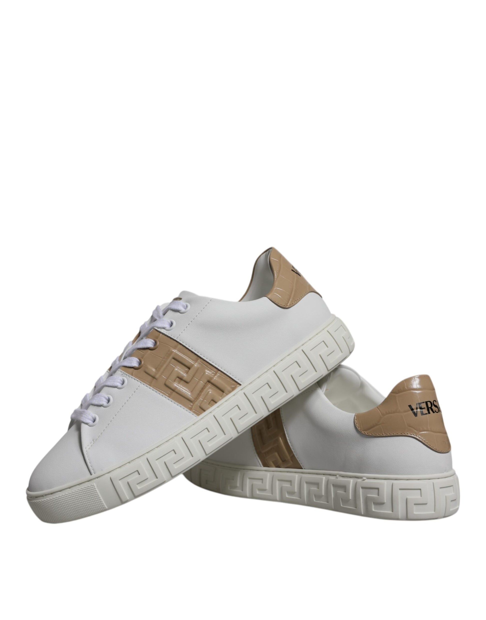 Pair of white sneakers with tan accents and a patterned sole