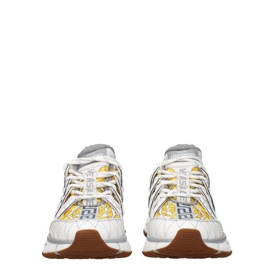 Pair of white athletic sneakers with yellow accents, featuring a logo on the side and laces