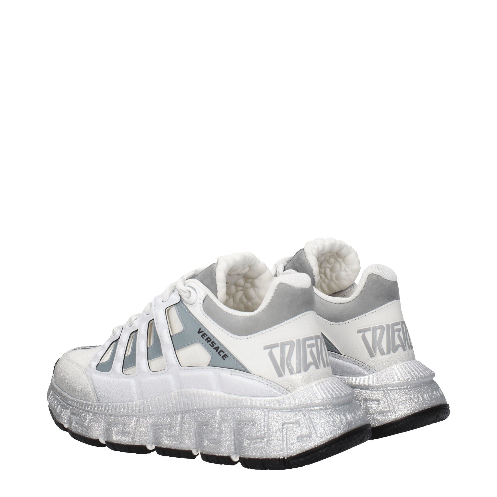 White athletic sneakers with silver accents, featuring the Versace logo on side