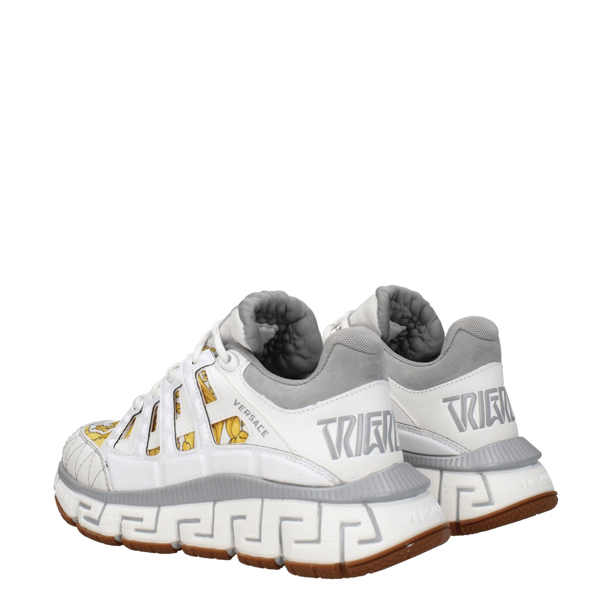 Pair of white athletic sneakers with gold accents, featuring brand name on side and sole