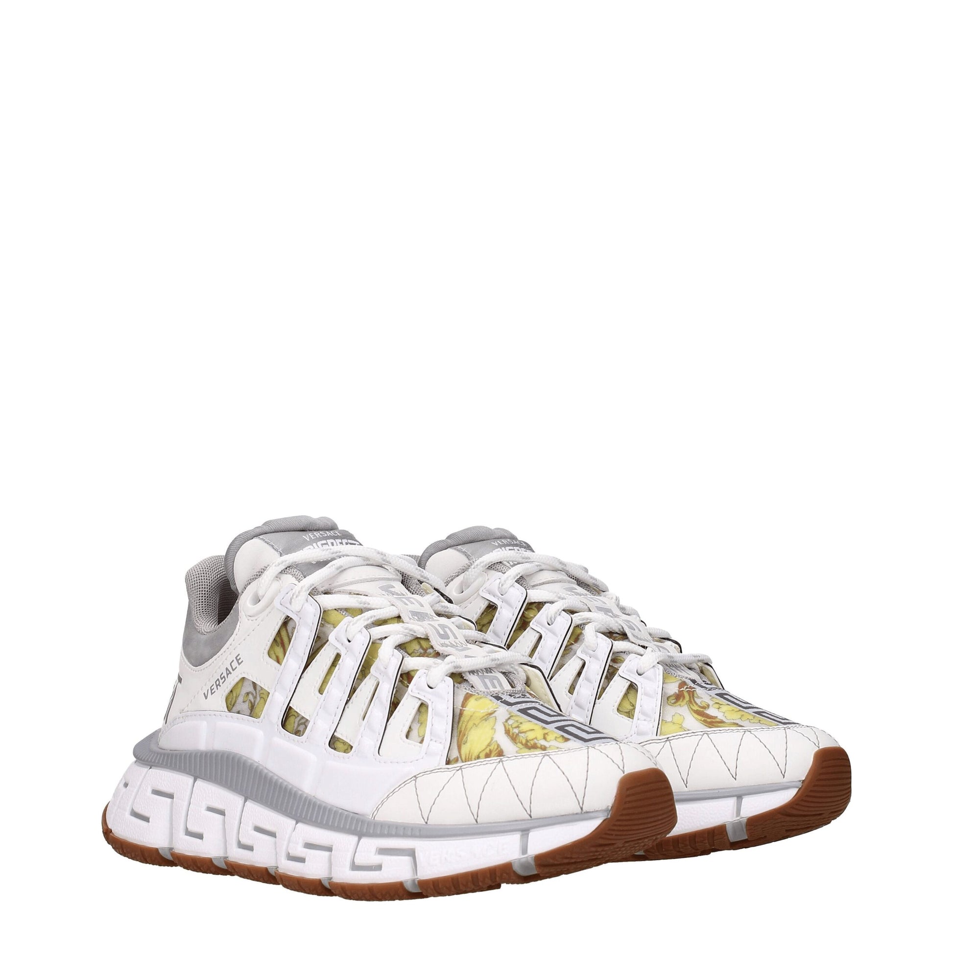 Pair of white leather athletic sneakers with gold accents, featuring a low-top design and lace closure