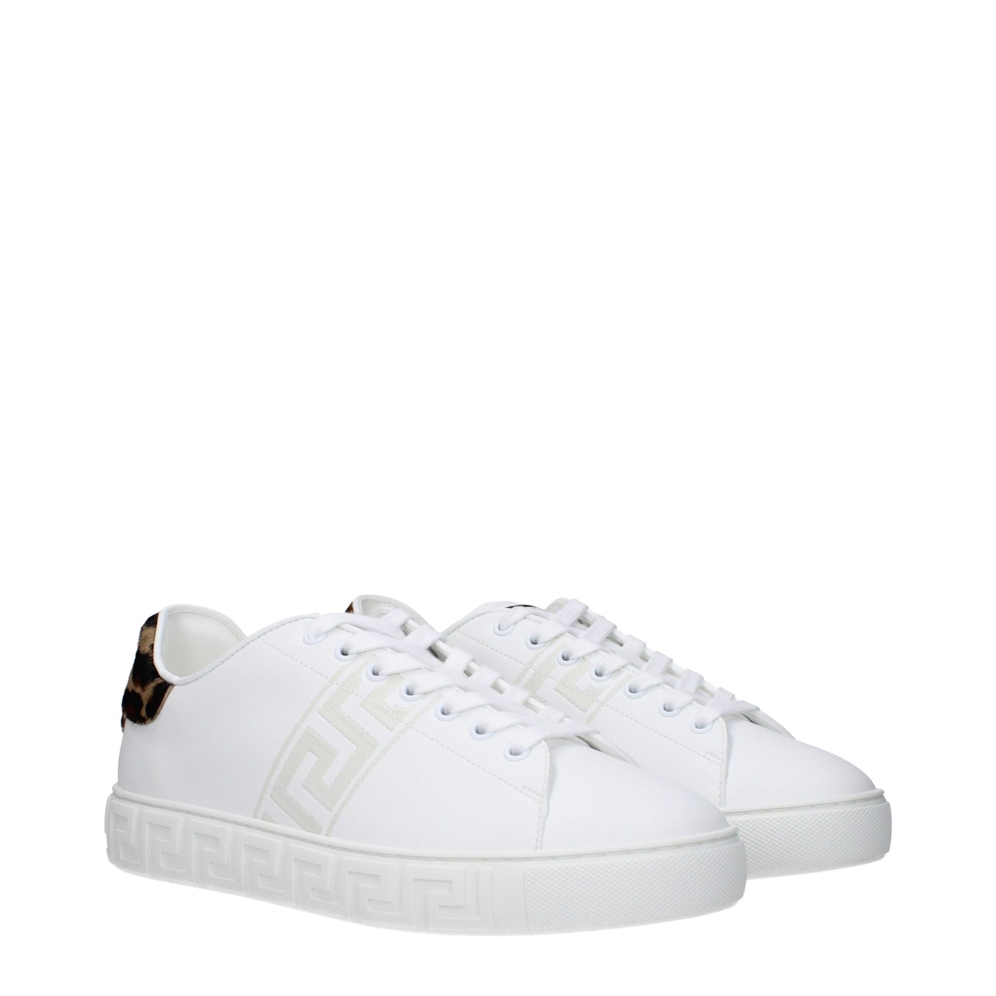 White leather low top sneakers with gold accents, featuring a distinctive logo on side and back
