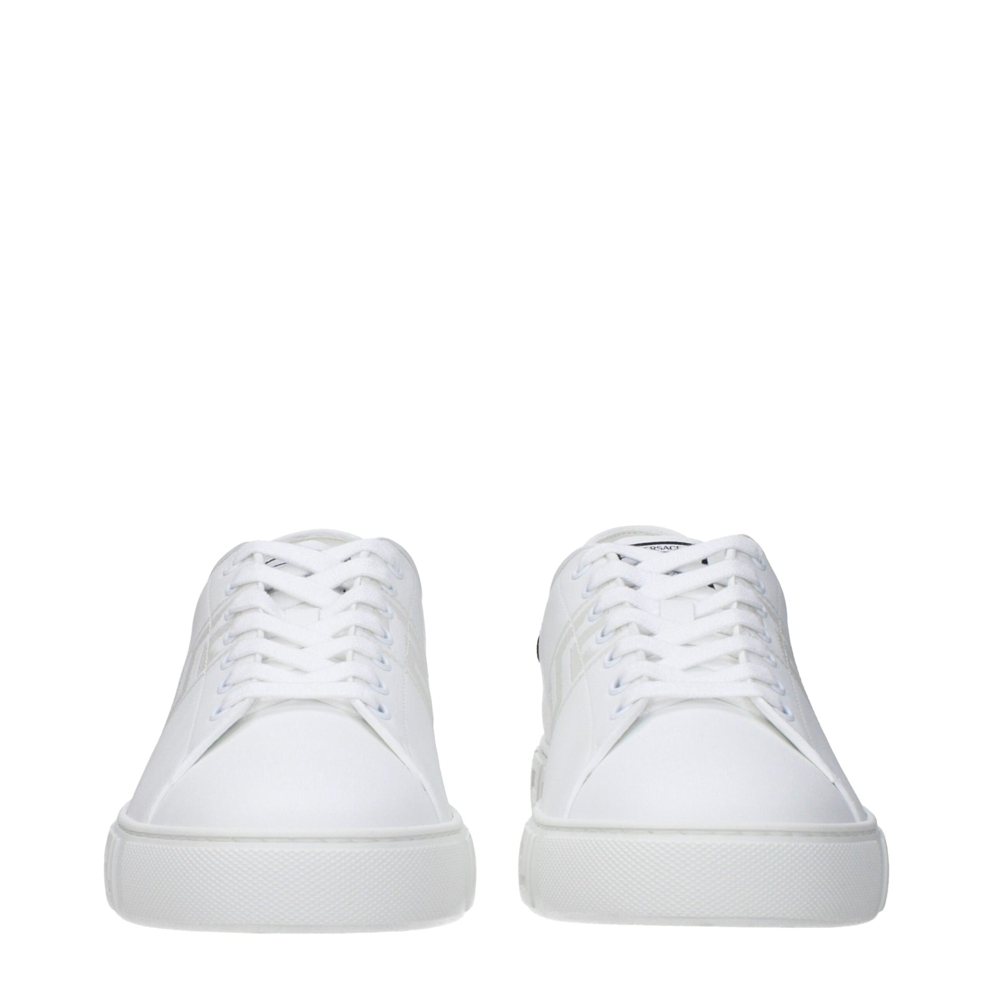 Pair of white leather low top sneakers with laces, featuring a flat sole and a minimalistic design