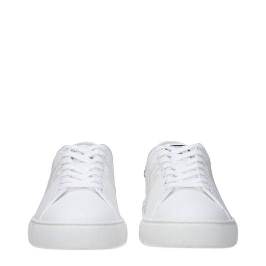Pair of white leather low top sneakers with laces, featuring a flat sole and a minimalistic design