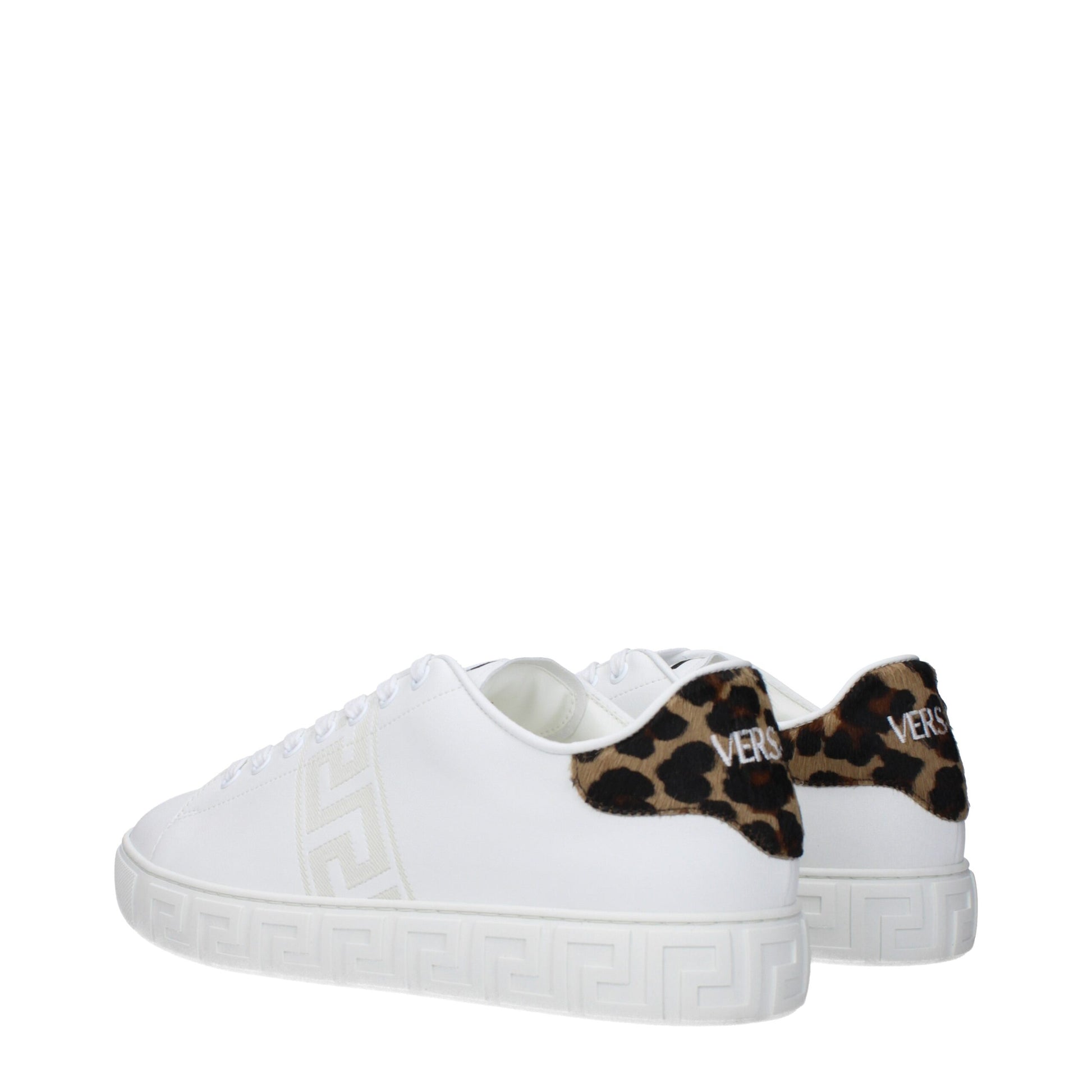 A pair of white leather sneakers with a low top, featuring a cheetah print design on the side and a gold buckle
