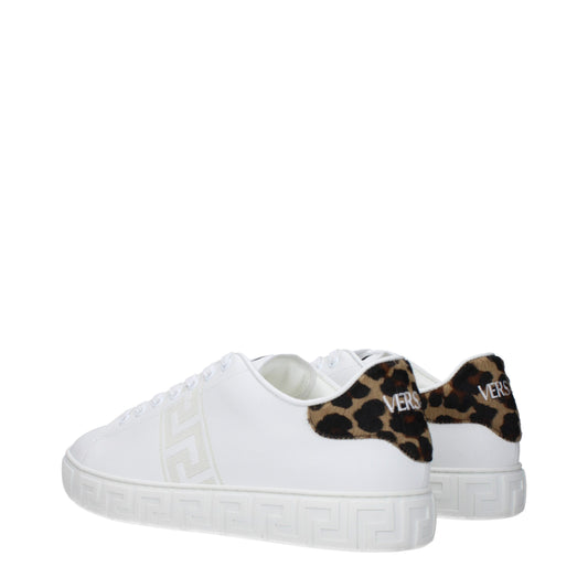 A pair of white leather sneakers with a low top, featuring a cheetah print design on the side and a gold buckle