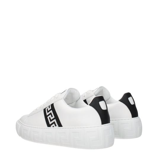 A pair of white leather sneakers with black laces, featuring a low top design and a distinctive pattern on the side