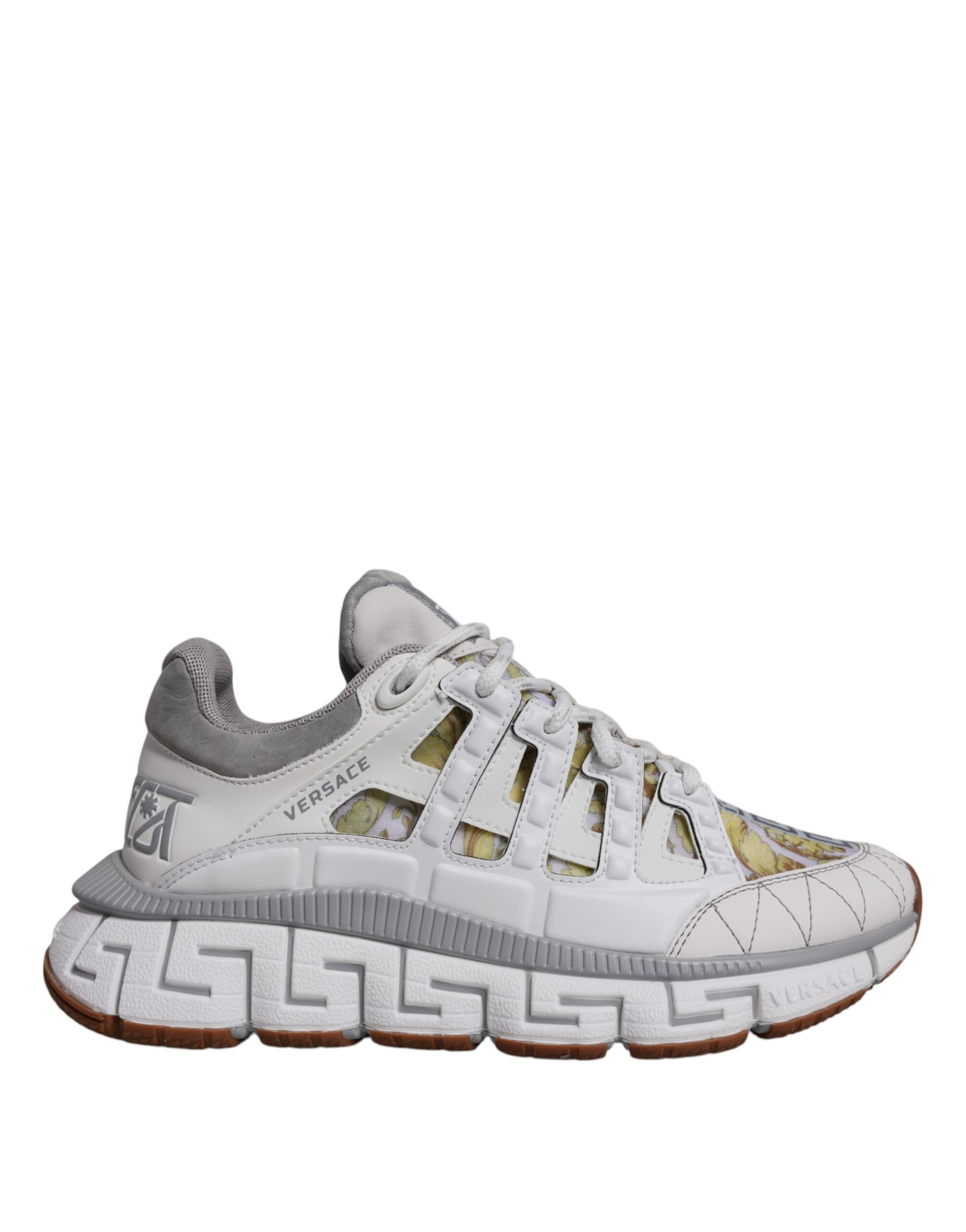 White sneaker with gold accents and a patterned sole