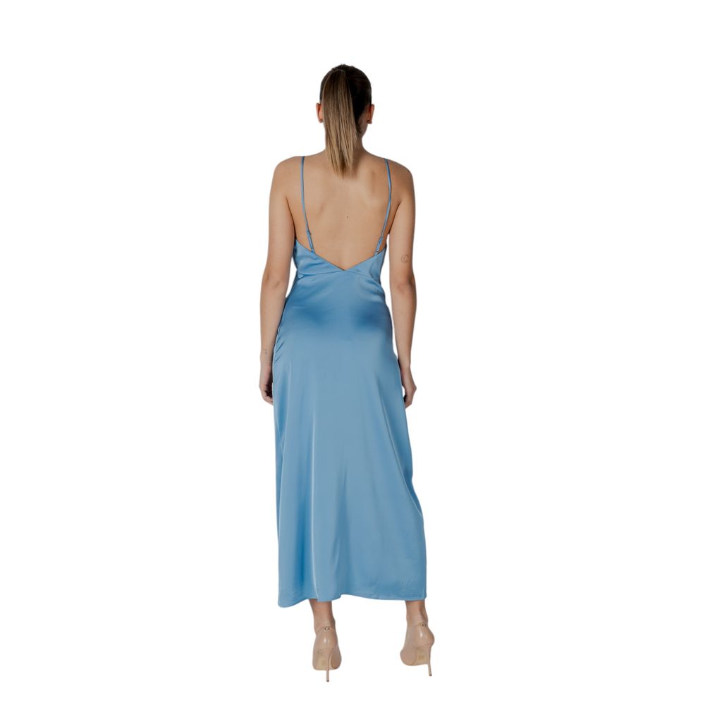 A long turquoise dress with a backless design, made of polyester fabric